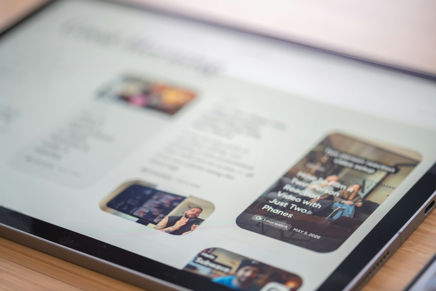 Tablet displaying webpages on a wooden table.