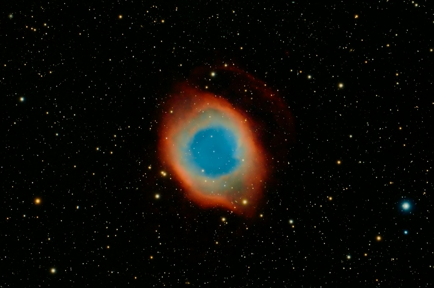 A glowing nebula with blue, orange, and red gases.